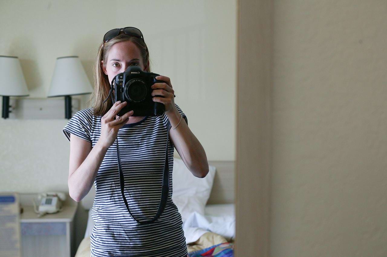 Image of Poppy De Villeneuve photographing herself in a mirror